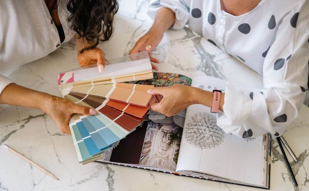 An aerial shot of two women looking at colour palettes and visuals for branding