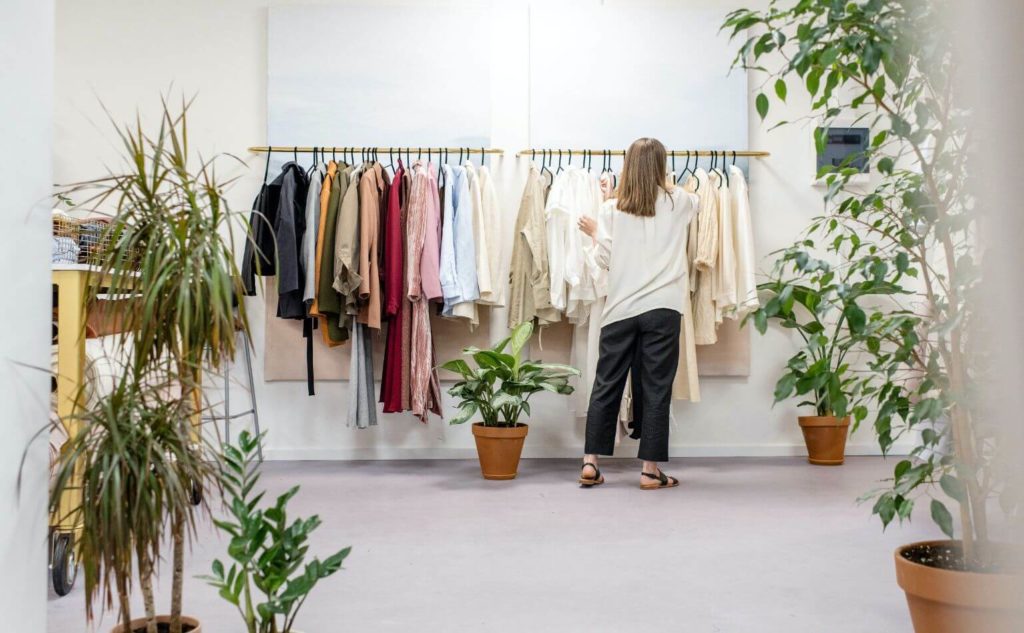 A boutique retail store with a woman shopping for clothing, having a sensory marketing experience